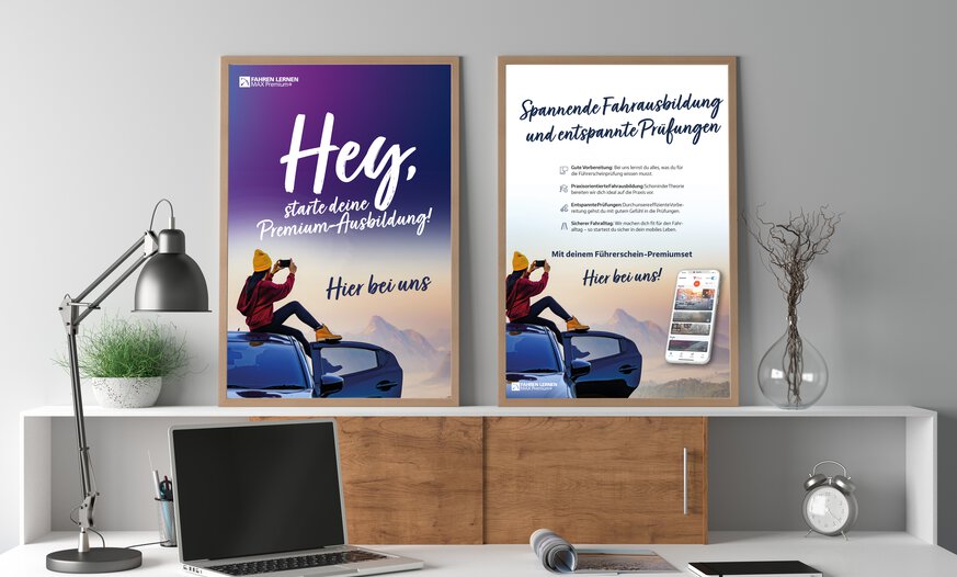 Zwei Poster in Holzrahmen auf Schreibtisch stehend an Wand gelehnt zum Thema Premium-Ausbildung mit Fahren Lernen Max Premium